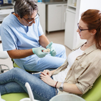 Dentist talking to patient in dental chair