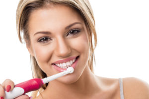 woman smiling with electric toothbrush