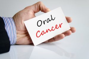 left hand holding oral cancer sign